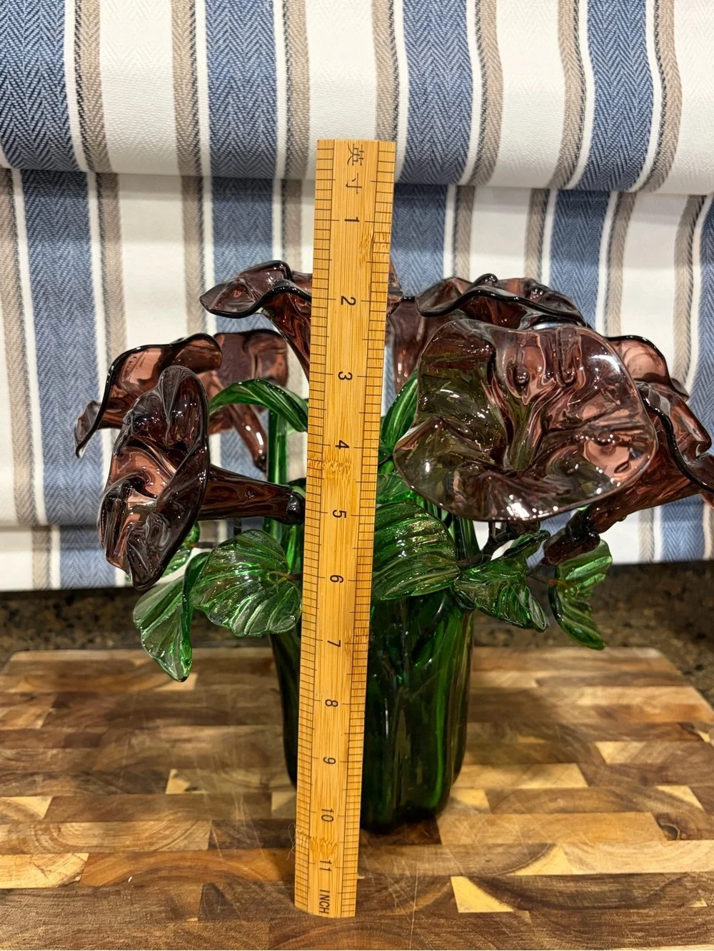 Vintage green swing glass vase with purple lily trumpet flowers.